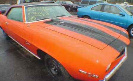 Orange with black stripes 1969 Camaro Z28 with dz302 engine and rally wheels with cowl induction hood for sale.